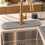 The Trivelle stone faucet mat fitted around a brass faucet base to catch splashes on the counter