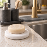 A bar of soap resting on the white Trivelle stone soap tray on a kitchen counter