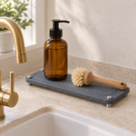 Dark Gray — Dark gray stone sink caddy holding an amber soap bottle and a wooden dish brush