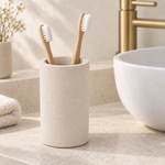 Beige — Beige stone brush cup on a counter beside a basin