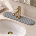 Dark Gray — Dark gray stone faucet mat on a bathroom vanity behind a brass tap