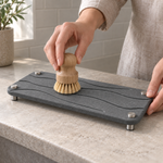 Dark Gray — Brushing the dark gray stone vanity tray clean with a wooden dish brush