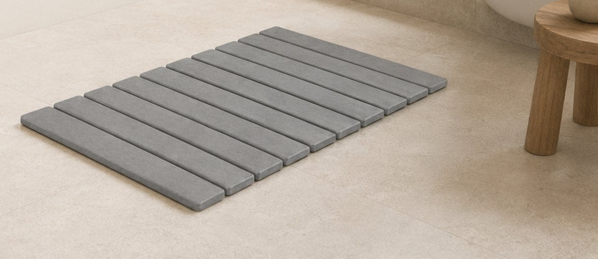 A diatomaceous stone mat resting beside a calm bathtub
